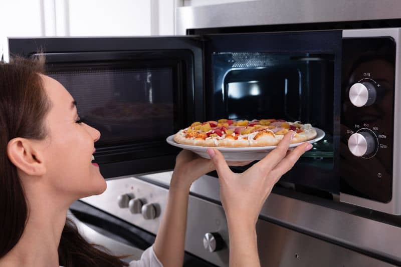 women-putting-pizza-in-microwave